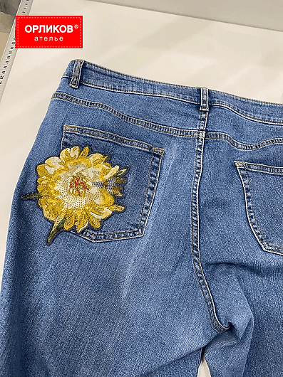Женские синие джинсы после ремонта художественной штопкой