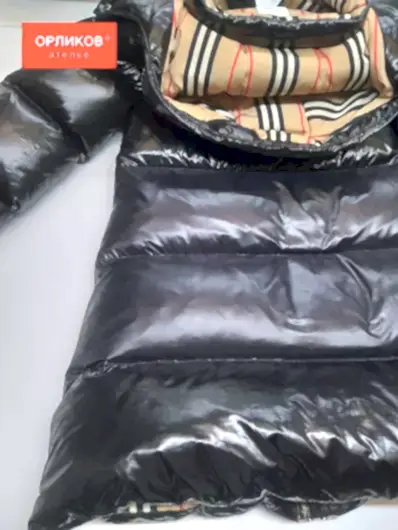 Черный женский пуховик после ремонта разрыва