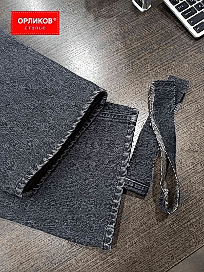 Черные джинсы после укорачивания с переносом края